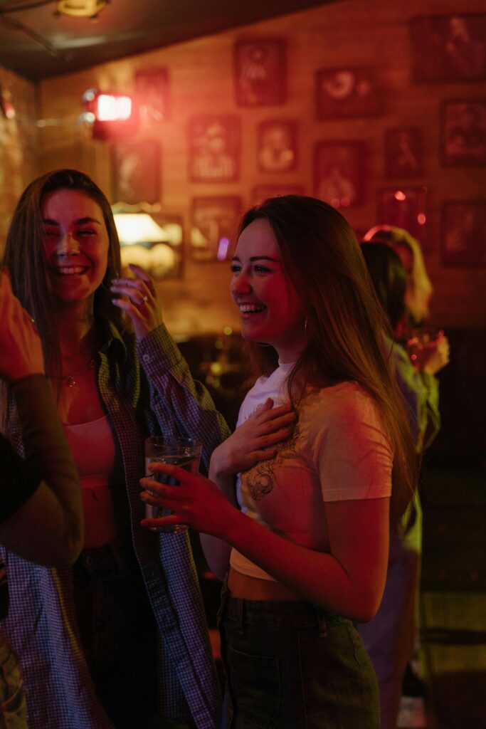 A lively group of young women enjoying a night out in a vibrant bar setting.